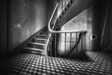 Grayscale of an old staircase and the lower floor.