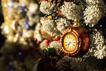 Fototapeta na wymiar Side view of holidays location with gold clock toys, garlands on Christmas tree