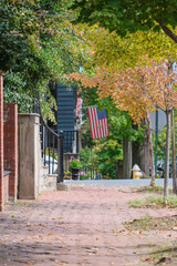 Beautiful picturesque New England style house facades in historic Old Town Alexandria, Virginia with shopping avenue mall King Street and romantic backstreet alley brick buildings colors Indian Summe