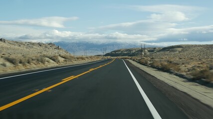 Road trip to Death Valley, driving auto in California, USA. Hitchhiking traveling in America. Highway, mountains and dry desert, arid climate wilderness. Passenger POV from car. Journey to Nevada.