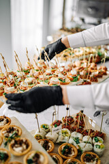 woman hands of a waiter prepare food for a buffet table in a restaurant