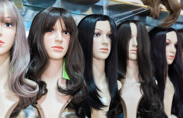 Fototapeta na wymiar Women's wigs are put on the shelf in a wig shop.