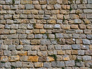 Rows of old stone blocks in an ancient wall. Taken on a sunny day.