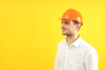 Businessman builder on yellow background, space for text