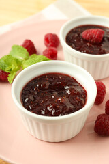 Concept of tasty food with raspberry jam on wooden background