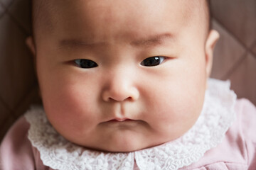 Close-up of Asian cute newborn baby looking at camera