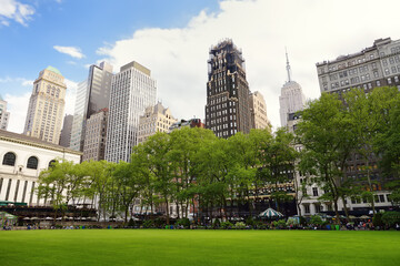 Fototapeta na wymiar New York, USA - May 11, 2021: People are relaxing and enjoying nice sunny spring day in Bryant Park in Manhattan, New York City
