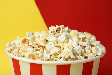 Striped paper cup with popcorn on two tone background