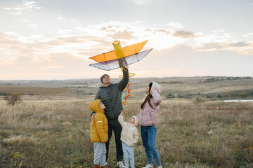 A happy family with kids launches a kite and spends time together in the fresh air. Happy childhood...