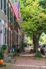 Beautiful picturesque New England style house facades in historic Old Town Alexandria, Virginia with shopping avenue mall King Street and romantic backstreet alley brick buildings colors Indian Summe
