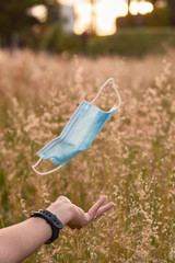 Concept end of pandemic. Young woman throwing masks