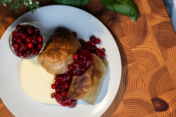Traditional Finnish cuisines; closeup of a plate of cabbage rolls with mashed potatoes and lingonberry jam.