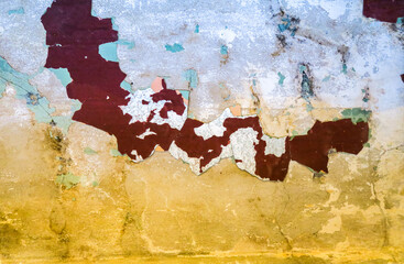 the texture of an old wall with cracks, scratches that can be used as a background. Vintage graffiti background in red, yellow and beige tones. Image of cracks in the paint.