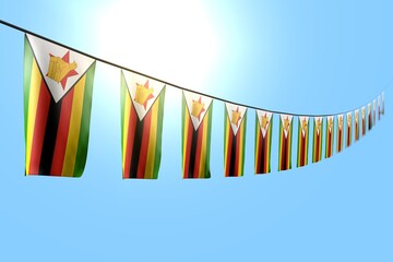nice independence day flag 3d illustration. - many Zimbabwe flags or banners hangs diagonal on rope on blue sky background with soft focus
