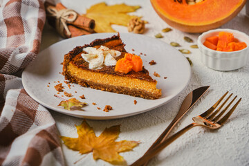 Homemade pumpkin cheesecake decorated with whipped cream.