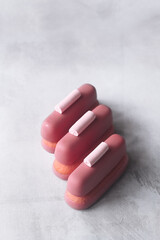 Ruby Chocolate and Raspberry Cookie Bars, garnished with meringue cookies, on grey background.
