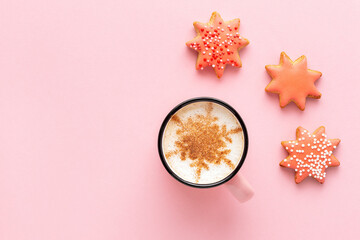Christmas coffee with star shaped biscuits on pastel pink background, top view. Gingerbread with...