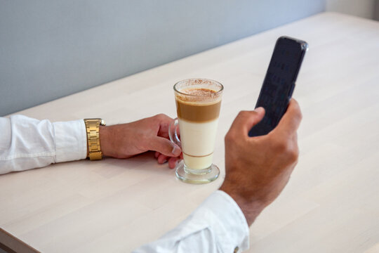 Hombre mirando el m&oacute;vil. Chico chateando con el m&oacute;vil. Hombre en cafeter&iacute;a con m&oacute;vil. Hombre tom&aacute;ndose un caf&eacute; en la cafeter&iacute;a. Chico escribiendo con el m&oacute;vil.