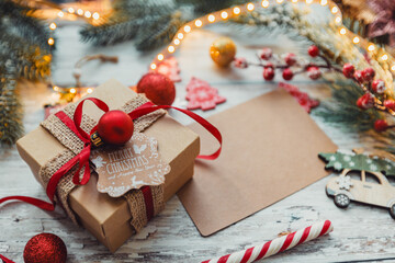 Christmas gift with a red ribbon on a wooden background with snowflakes. selective focus