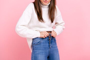 Close up portrait of young adult woman gaining weight, cant wearing her jeans, being overweight,...