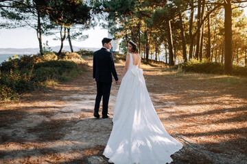 Just married couple walking by the woods