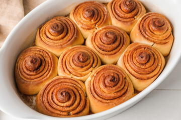 Baking dish with tasty cinnamon rolls on table