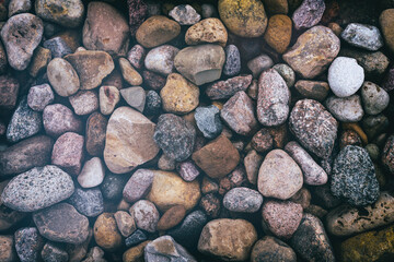small colorful rocks and pebbles as a background. Stone texture, vintage style
