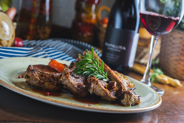 Fried ribs with a glass of red wine on a table in a restaurant close-up