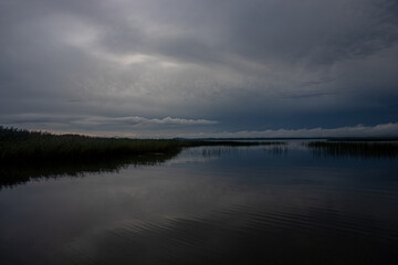 landscape of Latvian largest lake Razna, calm water in summer evening light.	