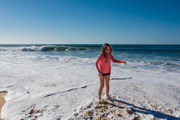 pretty young girl playing in the small waves