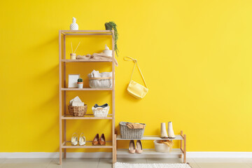 Interior of stylish hallway with shelving unit and shoes stand