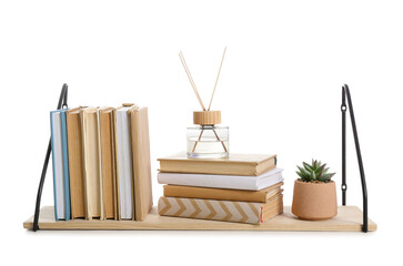 Wooden book shelf with flowerpot and reed diffuser on white background