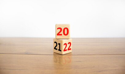 2022 happy new year symbol. Turned cubes, symbolize the change from 2021 to the new year 2022. Beautiful wooden table, white background. Copy space. Business and 2022 happy new year concept.