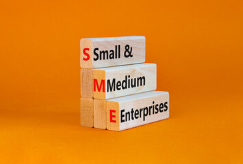 SME small and medium enterprises symbol. Words SME small and medium enterprises on blocks on a beautiful orange background. Business and SME small and medium enterprises concept. Copy space.