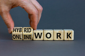 Hybrid or online work symbol. Businessman turns cubes and changes words 'online work' to 'hybrid work'. Beautiful grey background. Business, hybrid or online working concept, copy space. - obrazy, fototapety, plakaty