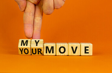 My or your move symbol. Businessman turns wooden cubes and changes words 'your move' to 'my move'. Beautiful orange table, orange background. My or your move and business concept. Copy space.