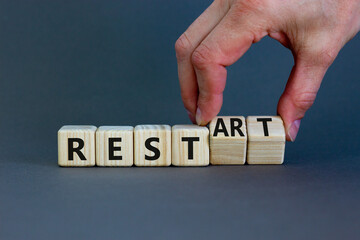 Rest and restart symbol. Businessman turns wooden cubes and changes the word 'rest' to 'restart'....