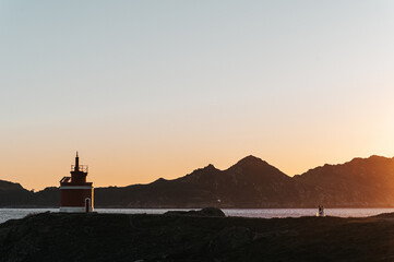 Landscape with a lighthouse and a just married couple walking