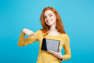 Close up Portrait young beautiful attractive redhair girl smiling showing digital tablet screen on...