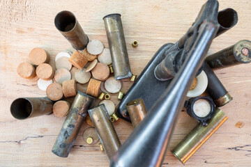 top view of cartridge cases, wads, primers and reloading press on wooden board