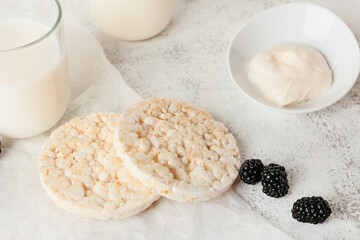 Puffed rice crackers, blackberry and sauce on light background, closeup