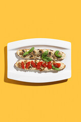 Plate with tasty bruschettas with vegetables on color background