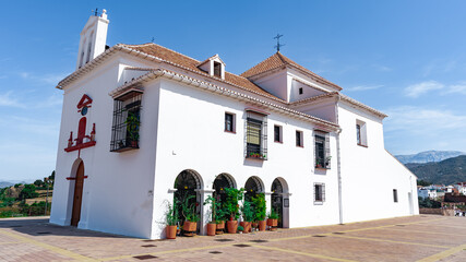Típica ermita de peregrinos con paredes blancas y tejas de barro un día soleado con cielo azul....