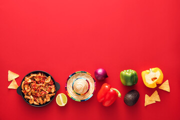 Composition with tasty Fajita, vegetables and sombrero hat on red background