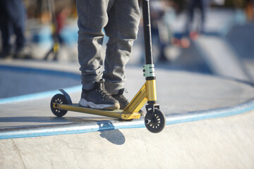 Boy rides on kick scooter in specializer skate park © hurricanehank
