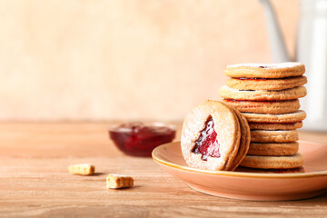 Plate with tasty Linzer cookies on wooden table