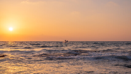Silhouette of man on a personal water craft on the  Mediterranean Sea at sunset at the coastline near Haifa, Israel
