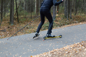 Fototapeta na wymiar Men ride roller skis in the autumn Park.