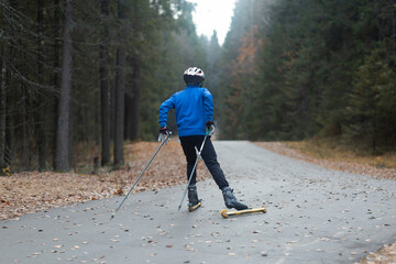 Men ride roller skis in the autumn Park.