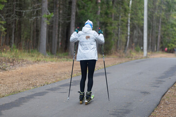Women ride roller skis in the autumn Park.